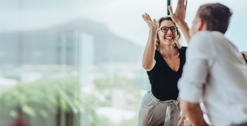 Businesswoman,Giving,A,High,Five,To,Male,Colleague,In,Meeting.