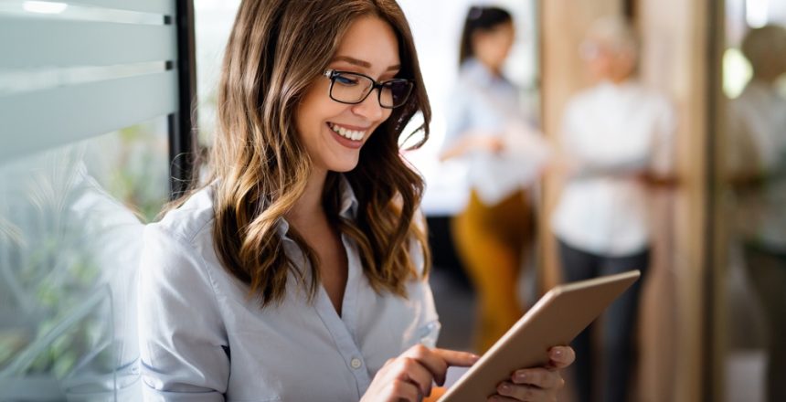 Attractive,Young,Businesswoman,Using,A,Digital,Tablet,While,Standing,In