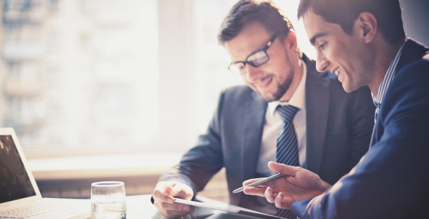 Image,Of,Two,Young,Businessmen,Using,Touchpad,At,Meeting