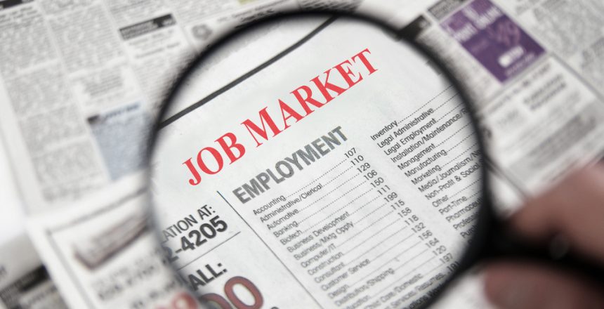 Magnifying,Glass,Over,A,Newspaper,Classified,Section,With,Job,Market